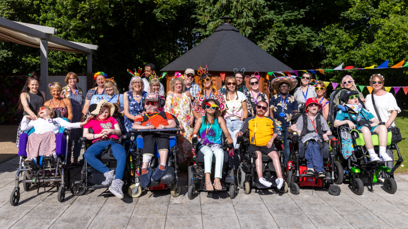 Group of young adults, family members, volunteers and staff outside in the Jacksplace garden at Jestival