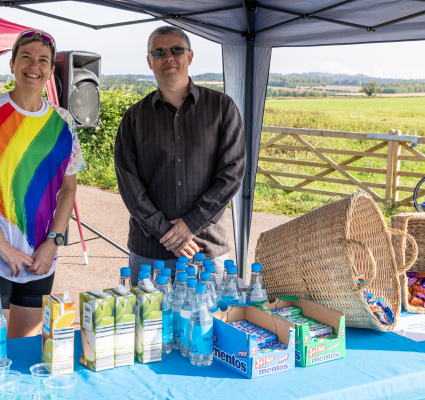 Man and women at pit stop for clarendon with water and sweets