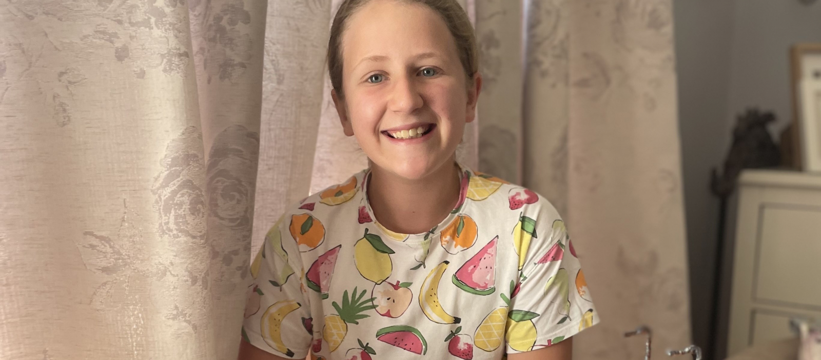 Jasmine smiling wearing fruit t-shirt