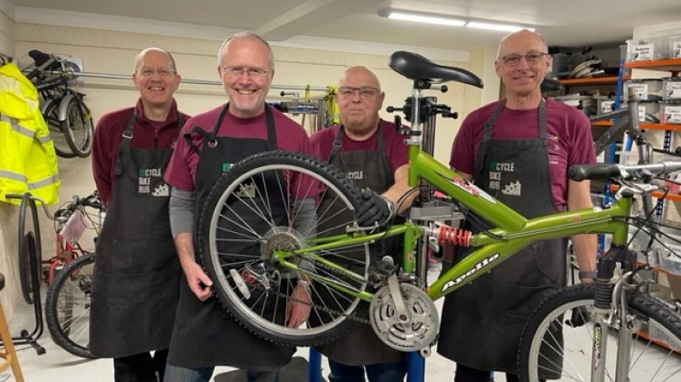 bike hub volunteers are smiling around a green bike