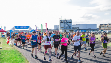A large group running on a runway at the start line