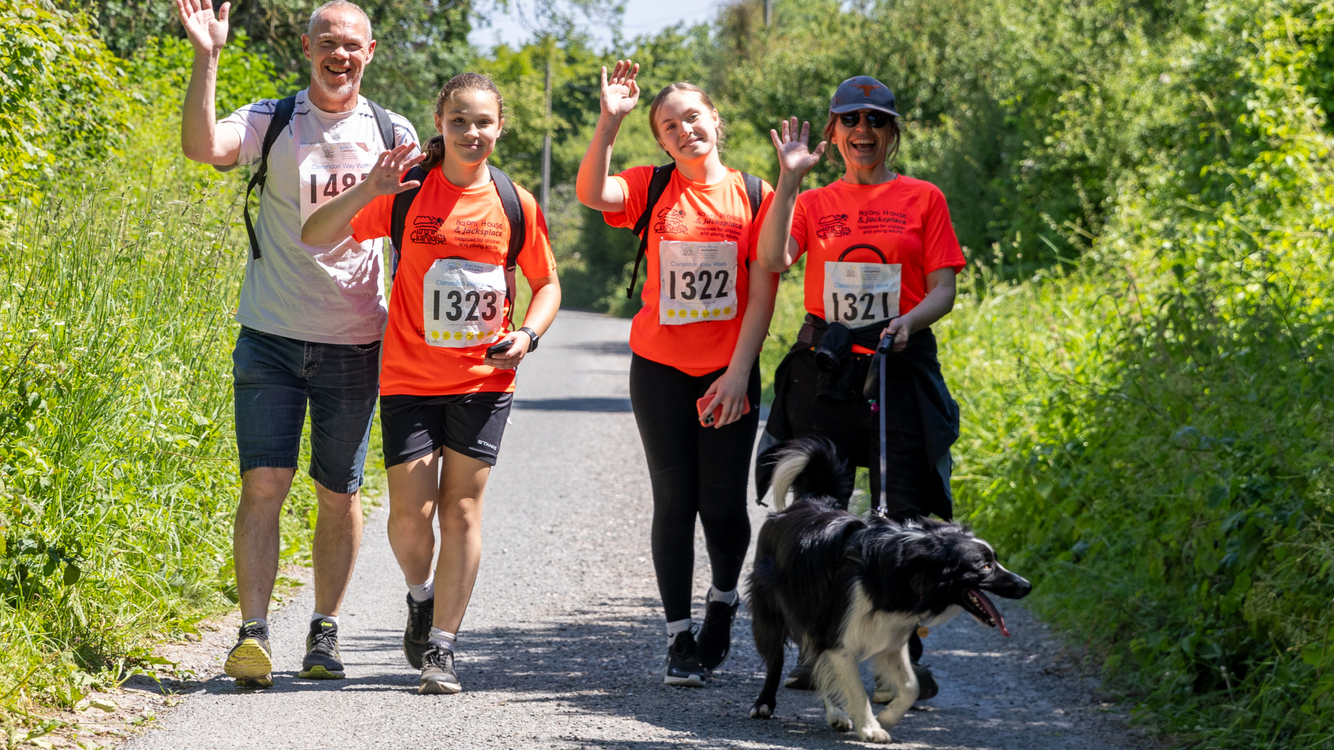 A group of people and dog walking and smiling