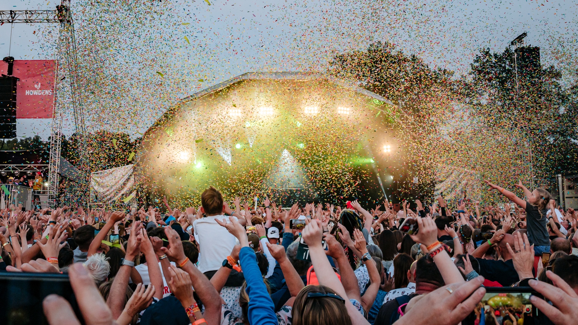 Hands of big crowd in front of stage with colourful confetti falling.jpg